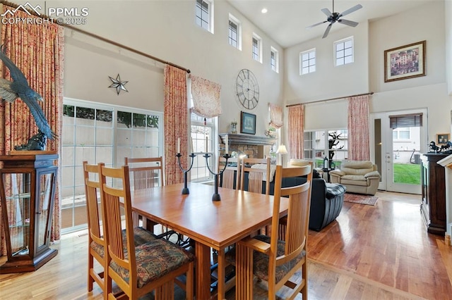 dining area featuring wood finished floors, a ceiling fan, a high ceiling, and recessed lighting