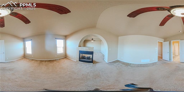 6018 Cumbre Vista Way, Colorado Springs, CO 80924 - unfurnished living room featuring a ceiling fan, vaulted ceiling, a tile fireplace, baseboards, and carpet floors