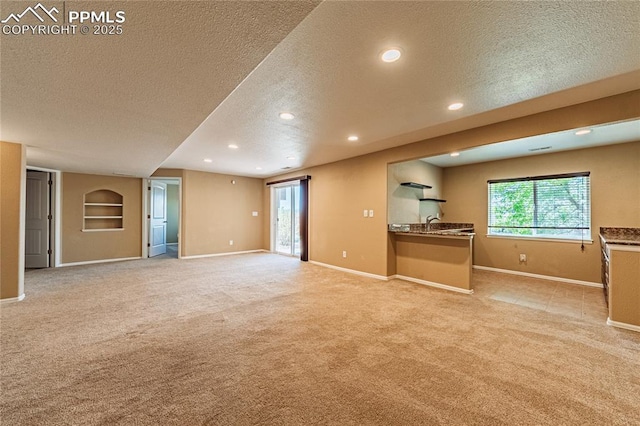 6018 Cumbre Vista Way, Colorado Springs, CO 80924 - unfurnished living room featuring a textured ceiling, light colored carpet, baseboards, and recessed lighting
