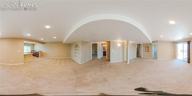 6018 Cumbre Vista Way, Colorado Springs, CO 80924 - unfurnished living room with vaulted ceiling, baseboards, carpet flooring, recessed lighting, and healthy amount of natural light