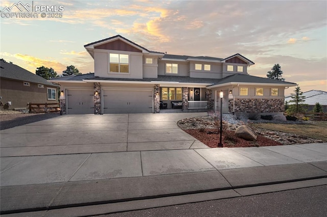 16231 Thunder Cat Way, Monument, CO 80132 - view of front of home featuring stone siding, covered porch, an attached garage, and driveway
