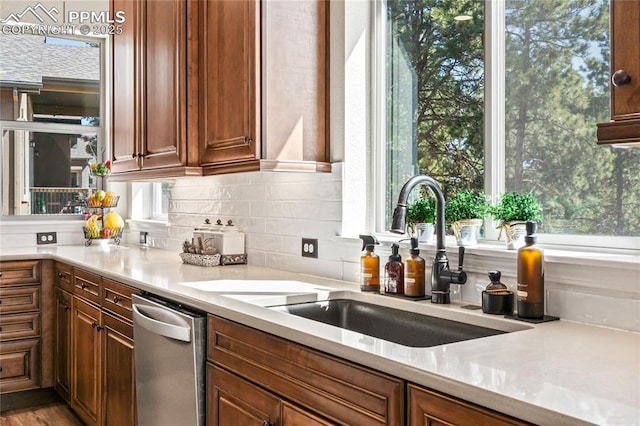 16231 Thunder Cat Way, Monument, CO 80132 - kitchen featuring a sink, stainless steel dishwasher, tasteful backsplash, light countertops, and plenty of natural light