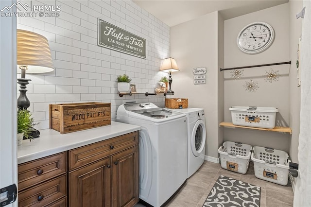 16231 Thunder Cat Way, Monument, CO 80132 - clothes washing area featuring separate washer and dryer, cabinet space, light tile patterned flooring, and baseboards