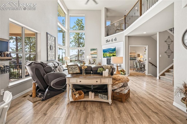 16231 Thunder Cat Way, Monument, CO 80132 - living room featuring a high ceiling, wood finished floors, stairs, and baseboards