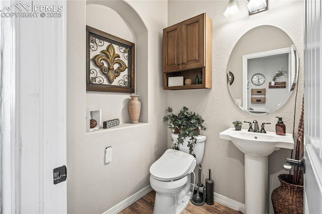 16231 Thunder Cat Way, Monument, CO 80132 - half bath featuring wood finished floors, toilet, a sink, and baseboards