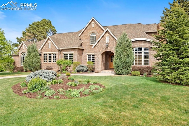 17 Marland Rd, Colorado Springs, CO 80906 - view of front facade with brick siding, a front lawn, and a shingled roof