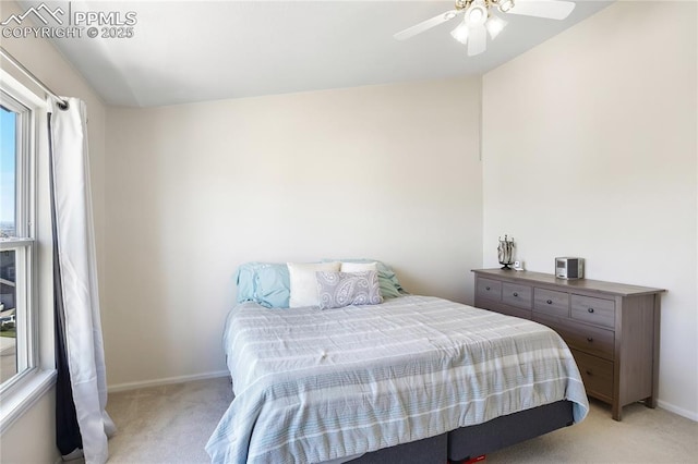 bedroom featuring light carpet, baseboards, and a ceiling fan