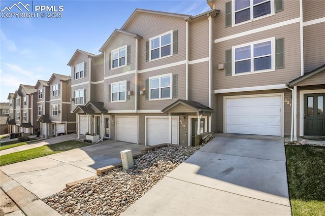 view of property with an attached garage, driveway, and a residential view