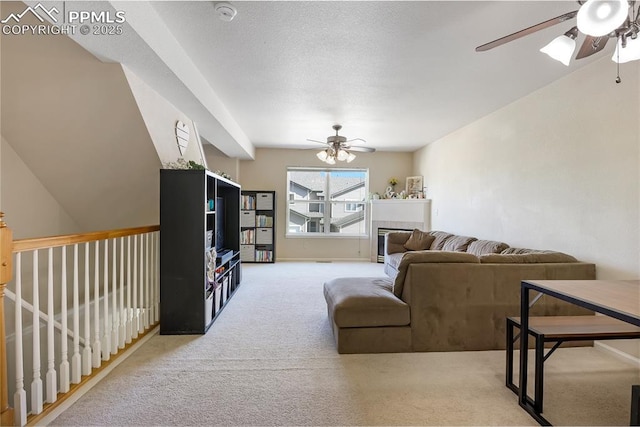 living room with ceiling fan, carpet flooring, and a tiled fireplace