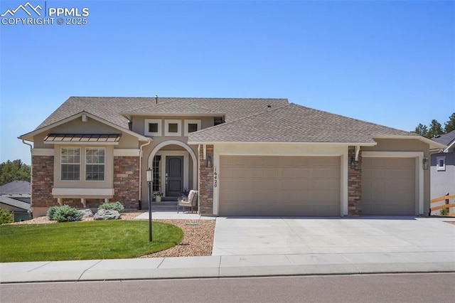16420 Mountain Glory Dr, Monument, CO 80132 - view of front of home with a garage, stone siding, concrete driveway, and stucco siding