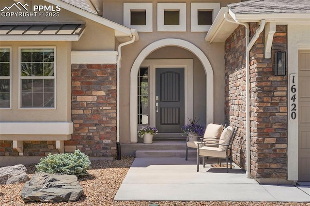 16420 Mountain Glory Dr, Monument, CO 80132 - property entrance with stone siding, roof with shingles, and stucco siding