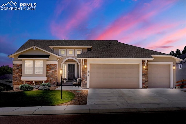 16420 Mountain Glory Dr, Monument, CO 80132 - view of front of house featuring an attached garage, stone siding, and concrete driveway
