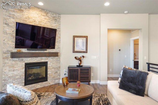 16420 Mountain Glory Dr, Monument, CO 80132 - living area featuring wood finished floors, recessed lighting, baseboards, and a stone fireplace