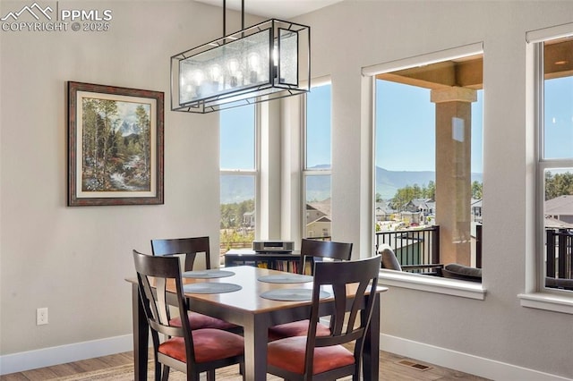 16420 Mountain Glory Dr, Monument, CO 80132 - dining area featuring baseboards, wood finished floors, a chandelier, and a mountain view