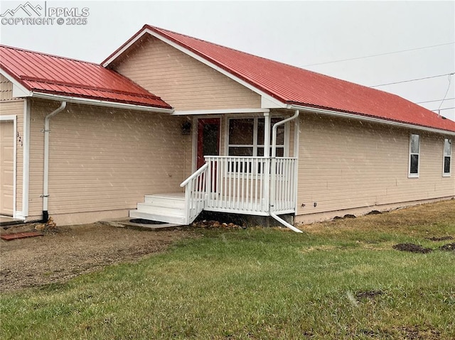 view of front facade featuring a front yard and metal roof