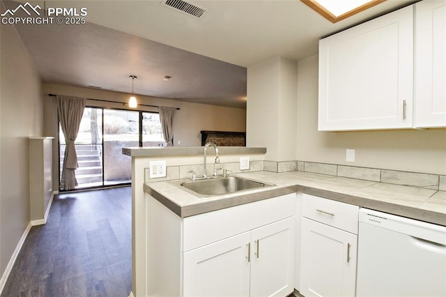 124 W Rockrimmon Blvd Unit 103, Colorado Springs, CO 80919 - kitchen featuring white dishwasher, a sink, a peninsula, dark wood finished floors, and white cabinetry