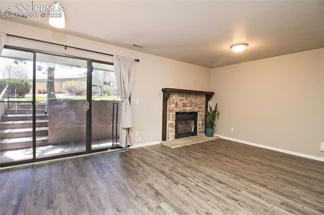 124 W Rockrimmon Blvd Unit 103, Colorado Springs, CO 80919 - unfurnished living room featuring wood finished floors, baseboards, and a fireplace