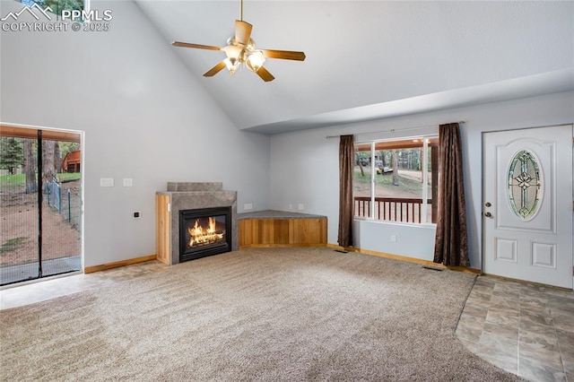 16 Echo Cir, Florissant, CO 80816 - unfurnished living room featuring high vaulted ceiling, a ceiling fan, a glass covered fireplace, baseboards, and stone finish floors