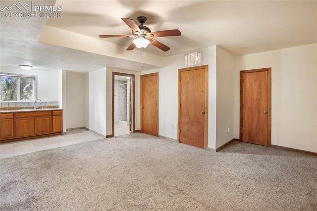16 Echo Cir, Florissant, CO 80816 - unfurnished bedroom with a sink, light colored carpet, ensuite bathroom, baseboards, and two closets
