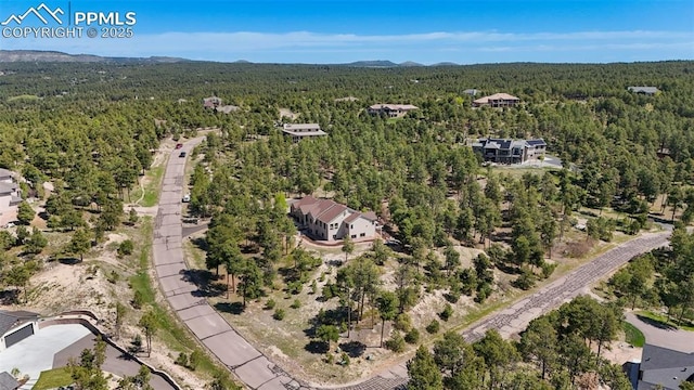 17575 Minglewood Trl, Monument, CO 80132 - aerial view of property's location featuring a heavily wooded area and a mountain backdrop