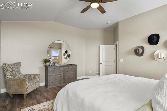 bedroom featuring wood finished floors, vaulted ceiling, baseboards, and ceiling fan
