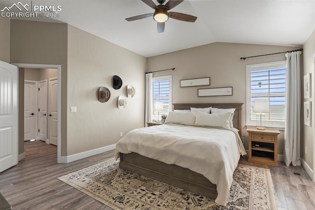 bedroom with vaulted ceiling, wood finished floors, baseboards, and a ceiling fan