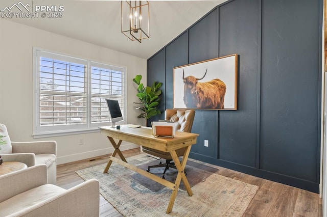 home office with a chandelier, baseboards, wood finished floors, and lofted ceiling