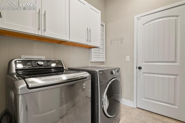 laundry area featuring cabinet space, washer and dryer, and baseboards
