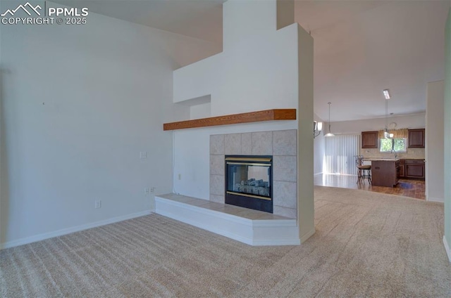 1670 Pinon Glen Cir, Colorado Springs, CO 80919 - unfurnished living room with carpet flooring, a fireplace, baseboards, and a sink