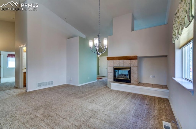 1670 Pinon Glen Cir, Colorado Springs, CO 80919 - unfurnished living room with carpet, a high ceiling, a chandelier, a tile fireplace, and baseboards