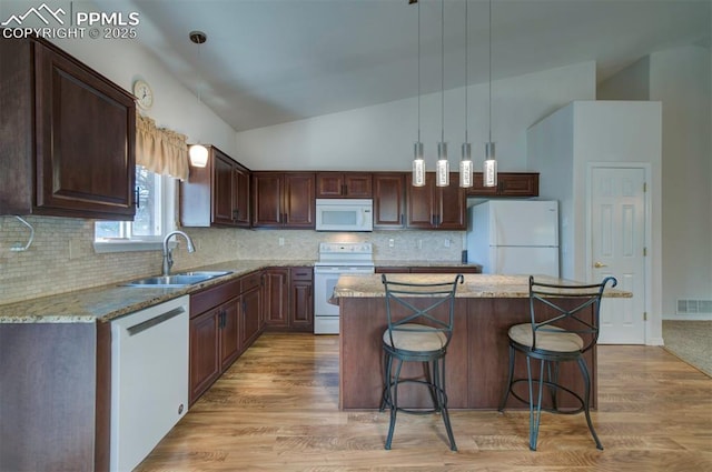 1670 Pinon Glen Cir, Colorado Springs, CO 80919 - kitchen with white appliances, a sink, vaulted ceiling, a center island, and light wood-type flooring