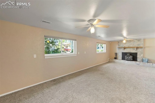 514 Dexter St, Colorado Springs, CO 80911 - unfurnished living room with carpet floors, a ceiling fan, baseboards, and a wood stove