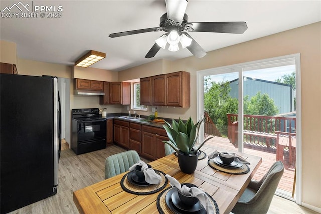 514 Dexter St, Colorado Springs, CO 80911 - kitchen with freestanding refrigerator, black range with electric cooktop, under cabinet range hood, a sink, and light wood-style floors