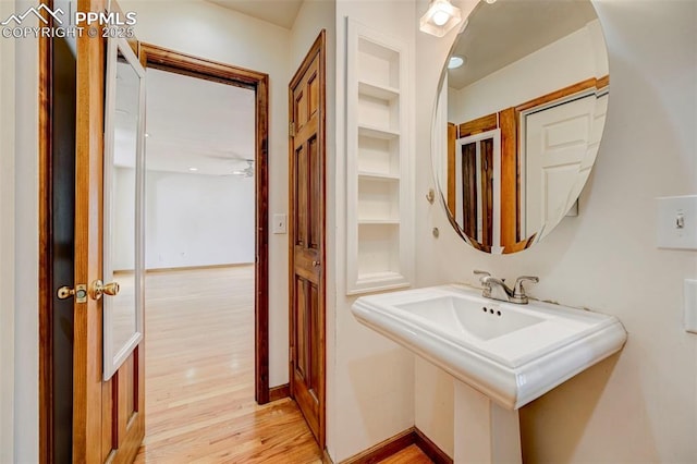 458 S Downing St, Denver, CO 80209 - bathroom featuring wood finished floors, a sink, built in features, and baseboards