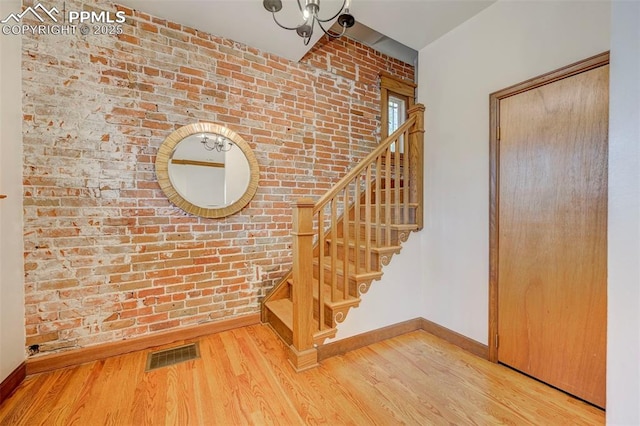 458 S Downing St, Denver, CO 80209 - staircase featuring brick wall, baseboards, and wood finished floors