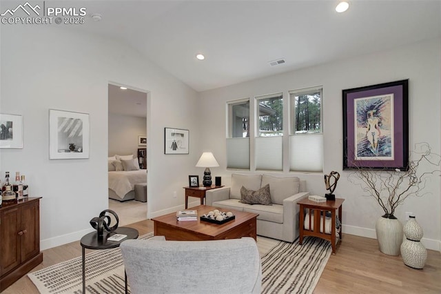 living area featuring light wood-style flooring, vaulted ceiling, baseboards, and recessed lighting