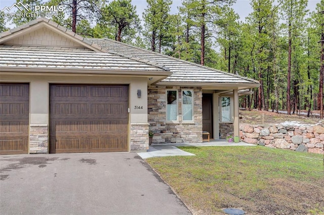 view of front of home with stone siding, a tile roof, and stucco siding