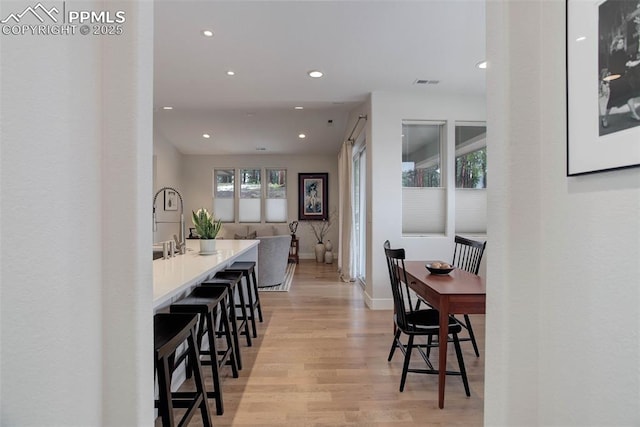 dining room with recessed lighting, light wood-type flooring, and baseboards