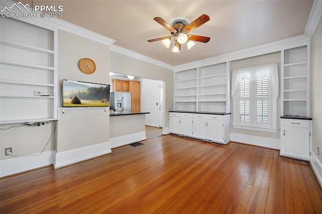 806 E Platte Ave, Colorado Springs, CO 80903 - unfurnished living room featuring built in shelves, ceiling fan, wood-type flooring, baseboards, and crown molding