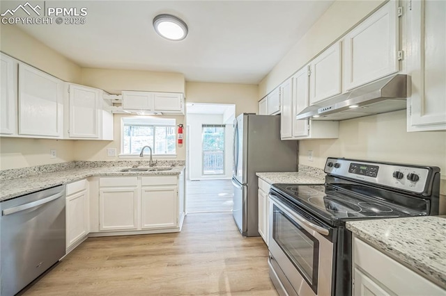 kitchen featuring stainless steel appliances, a sink, under cabinet range hood, white cabinetry, and light wood-style flooring