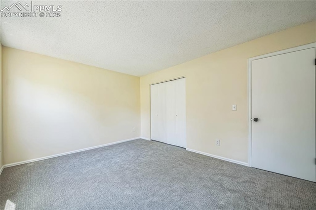 unfurnished bedroom featuring carpet, a closet, a textured ceiling, and baseboards