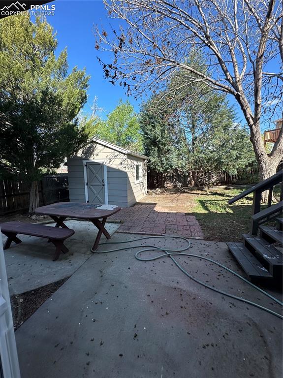 view of patio / terrace with a shed, an outbuilding, and a fenced backyard