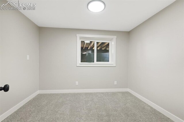 carpeted empty room featuring baseboards