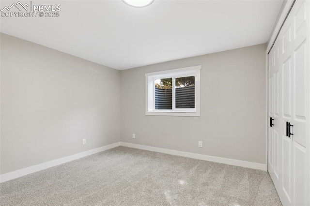 unfurnished bedroom with carpet, a closet, and baseboards