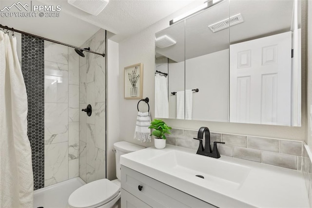 bathroom featuring toilet, a shower stall, vanity, and backsplash