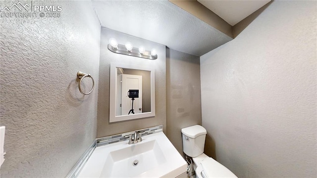 1636 Shenandoah Dr, Colorado Springs, CO 80910 - half bathroom featuring a textured wall, toilet, and vanity