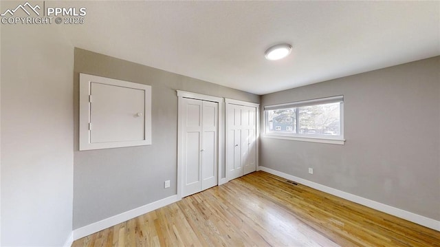 1636 Shenandoah Dr, Colorado Springs, CO 80910 - unfurnished bedroom featuring multiple closets, baseboards, and light wood-style flooring