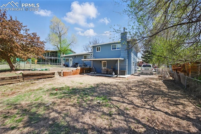 1636 Shenandoah Dr, Colorado Springs, CO 80910 - back of house featuring a chimney, a fenced backyard, a patio, and a garden