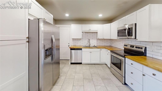 1636 Shenandoah Dr, Colorado Springs, CO 80910 - kitchen featuring stainless steel appliances, wood counters, a sink, light tile patterned flooring, and recessed lighting