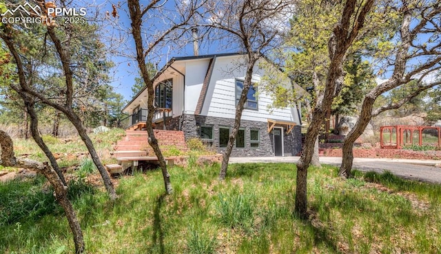 view of front of home featuring stone siding and stairway